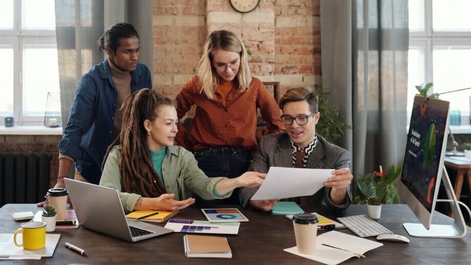 A group of people gathering around a table in an office and planning for their work.