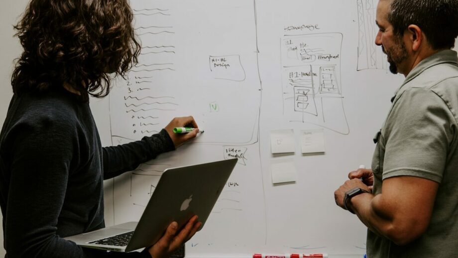 Two men working together on a whiteboard.