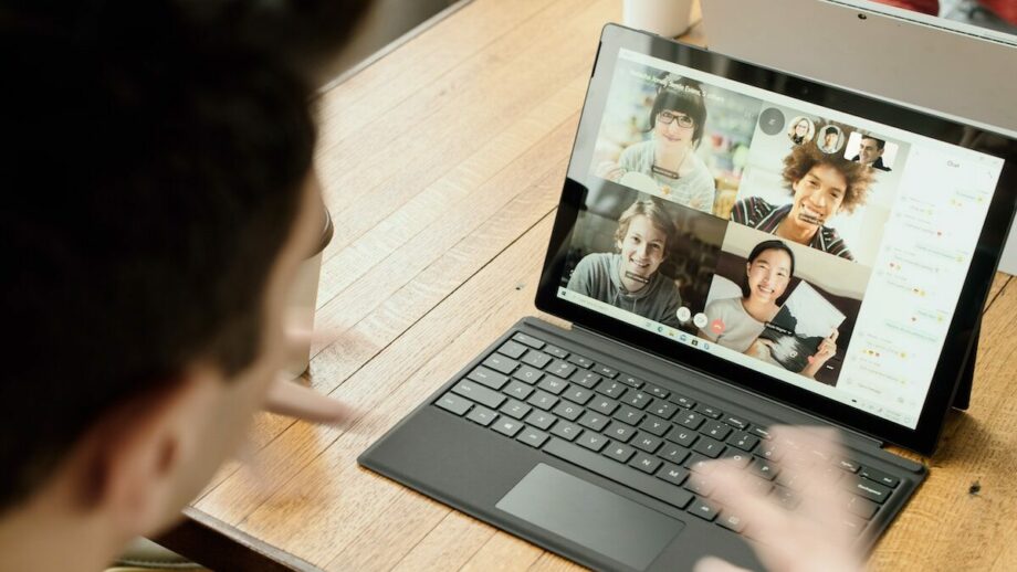 A man is sitting at a table with a laptop in front of him.