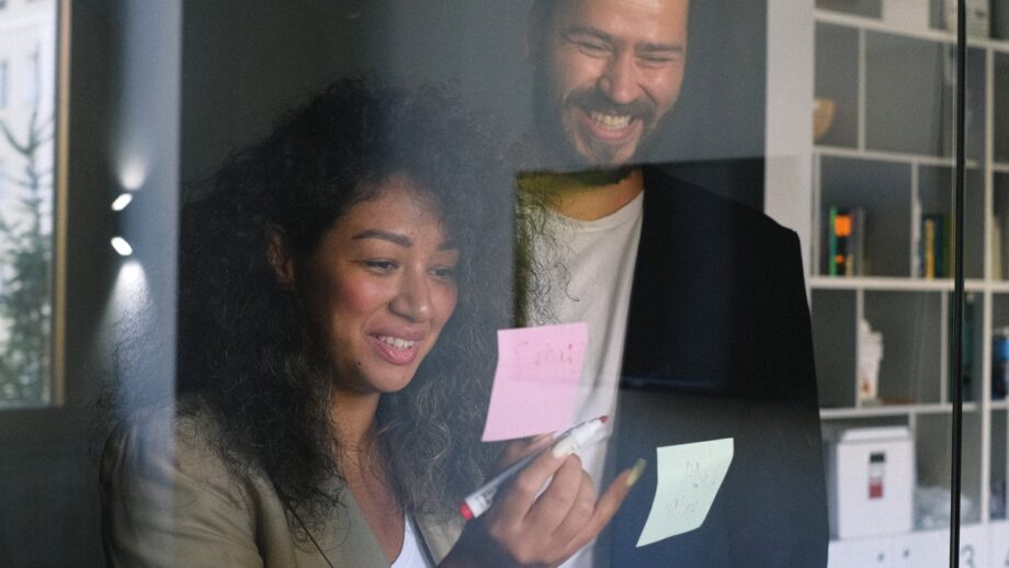 A man and a woman standing in front of a glass door.