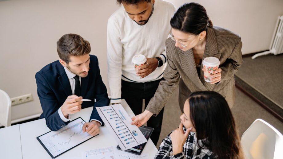 A group of businesspeople sitting around a table looking at performance graphs.