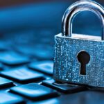 A silver padlock sits on a computer keyboard, symbolizing cybersecurity and data protection.